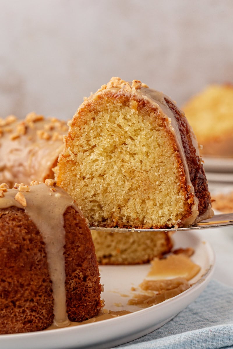 a slice of caramel swirl Bundt cake being lifted away from the remaining cake