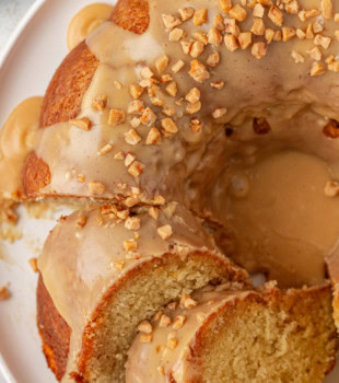 partially sliced caramel swirl Bundt cake on a white cake plate