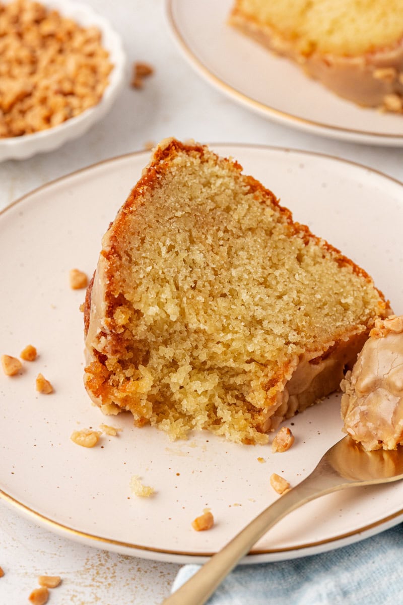a slice of caramel swirl Bundt cake on a white plate with a bite on a fork