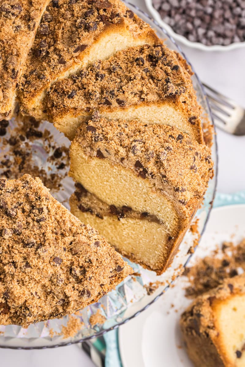 partially sliced chocolate chip crumb pound cake on a glass cake stand