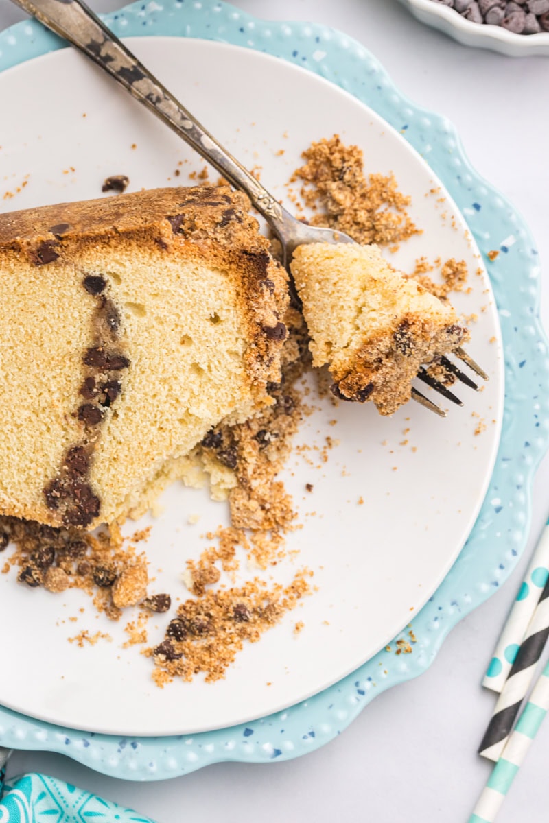 overhead view of a slice of chocolate chip crumb pound cake on a plate with a bite on a fork