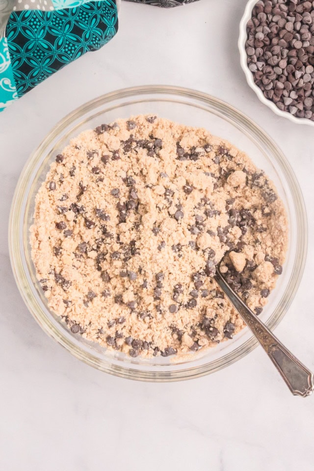 overhead view of chocolate chip crumb mixture in a glass mixing bowl