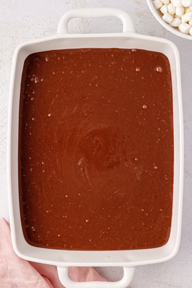 overhead view of chocolate cake batter in a white baking pan