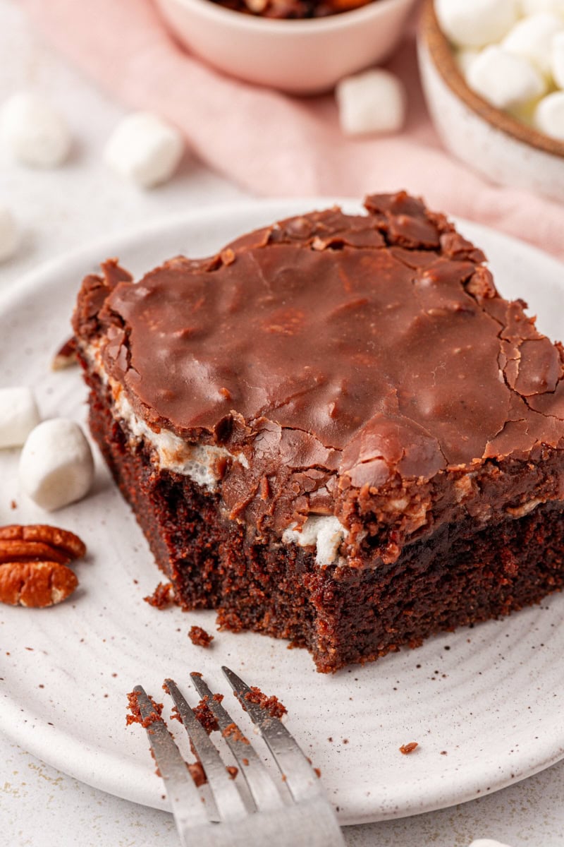 a slice of Mississippi mud cake on a white plate with a fork resting on the plate