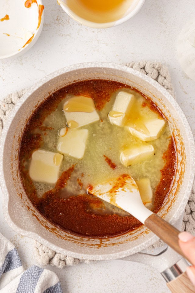 overhead view of butter added to caramel mixture in a saucepan