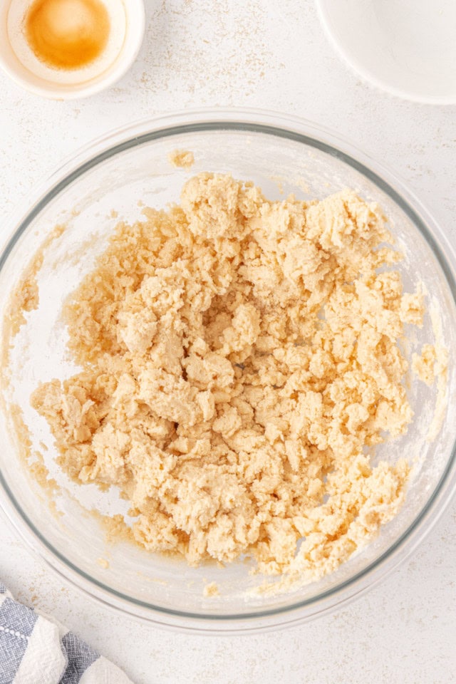 overhead view of shortbread crust dough in a glass mixing bowl