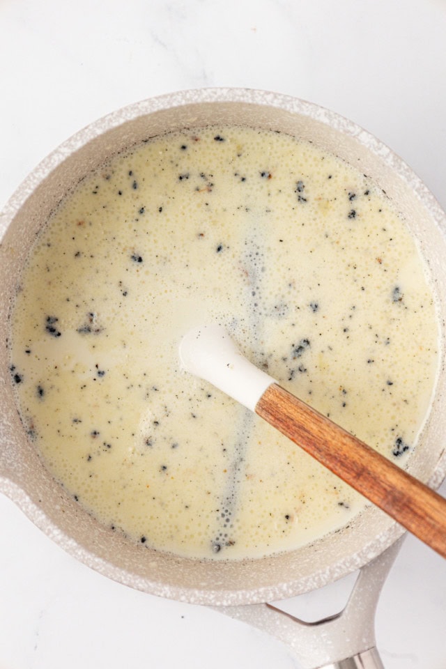 overhead view of heavy cream, milk, sugar, and a vanilla bean in a saucepan