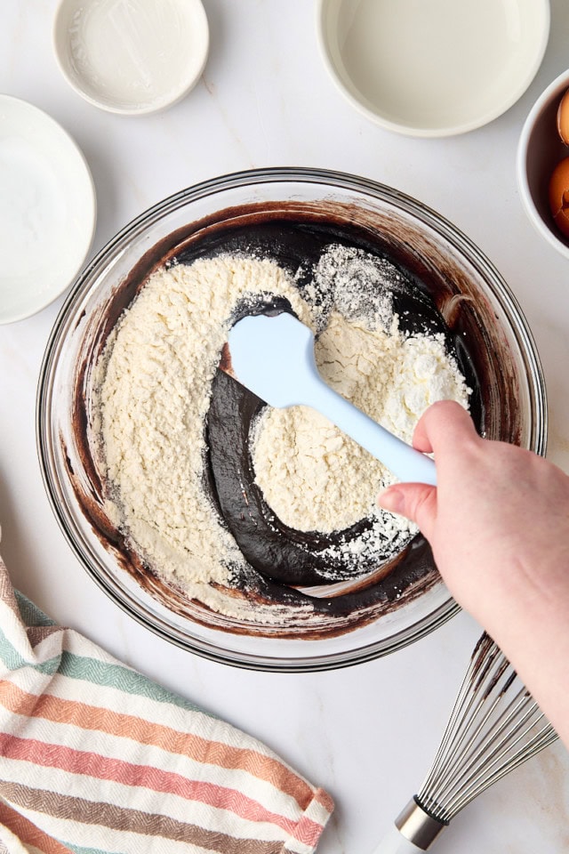 overhead view of flour and cornstarch being stirred into brownie batter
