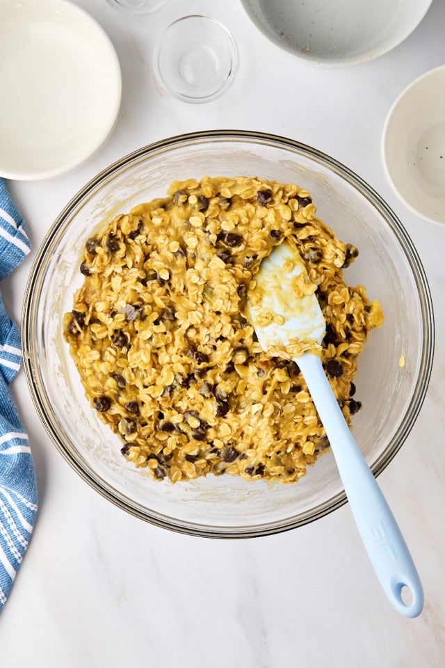 overhead view of oatmeal cookie bar batter in a glass mixing bowl