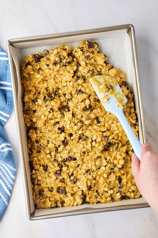 overhead view of oatmeal cookie bars being spread in a 9x13 pan