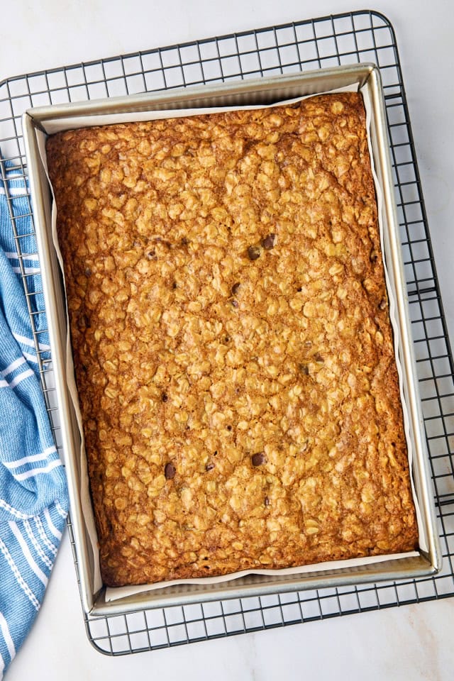 overhead view of freshly baked oatmeal cookie bars in a 9x13 pan set on a wire rack