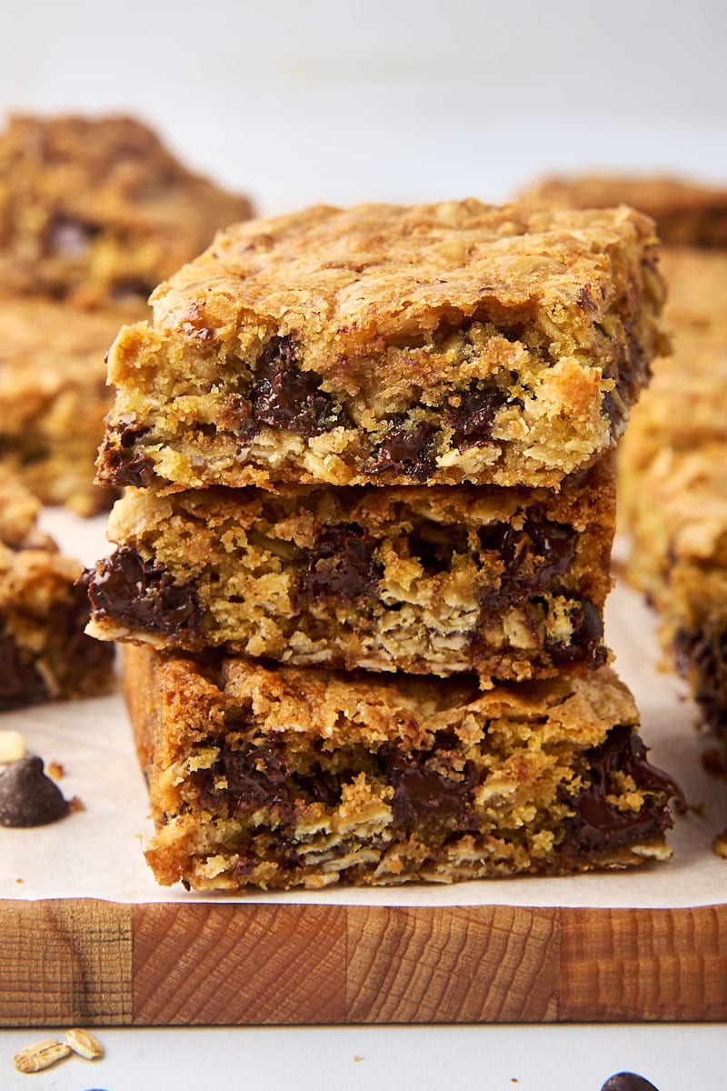 stack of three oatmeal cookie bars on a parchment-covered cutting board