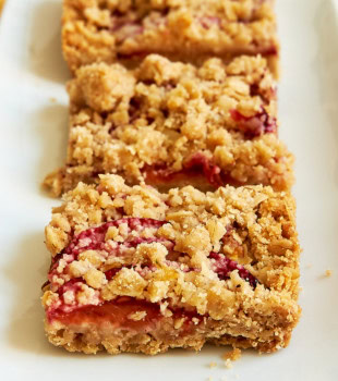 three plum crumble bars on a white plate