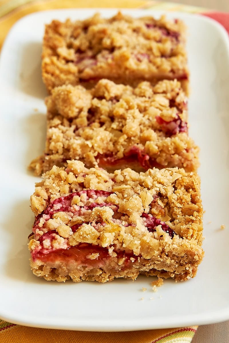 three plum crumble bars on a white plate