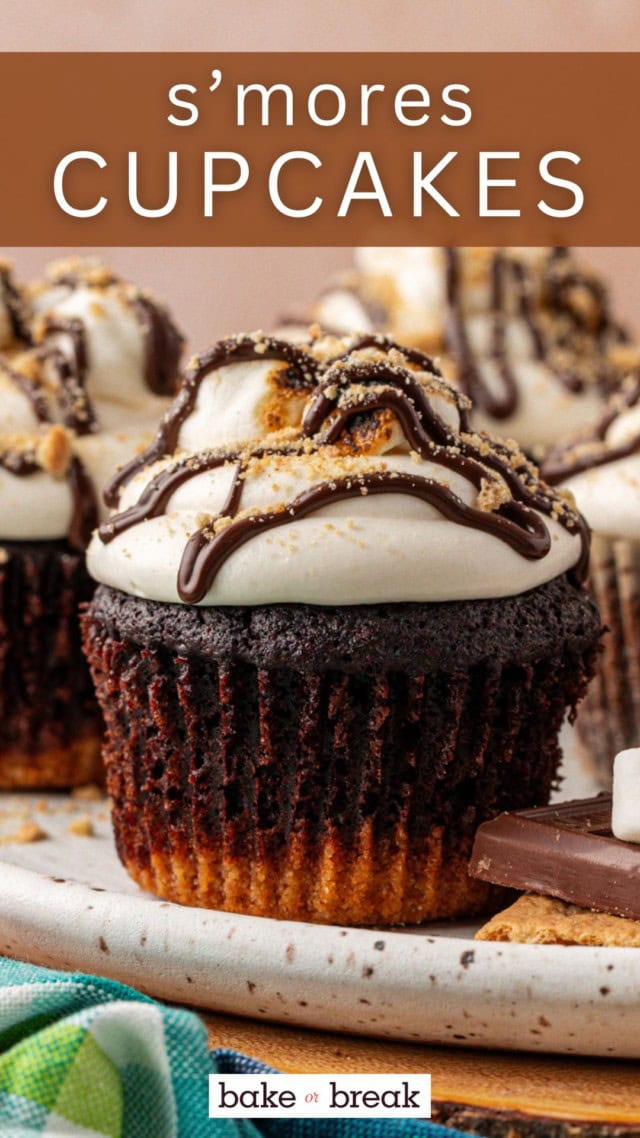a s'mores cupcake on a serving tray with more cupcakes in the background; text overlay "s'mores cupcakes"