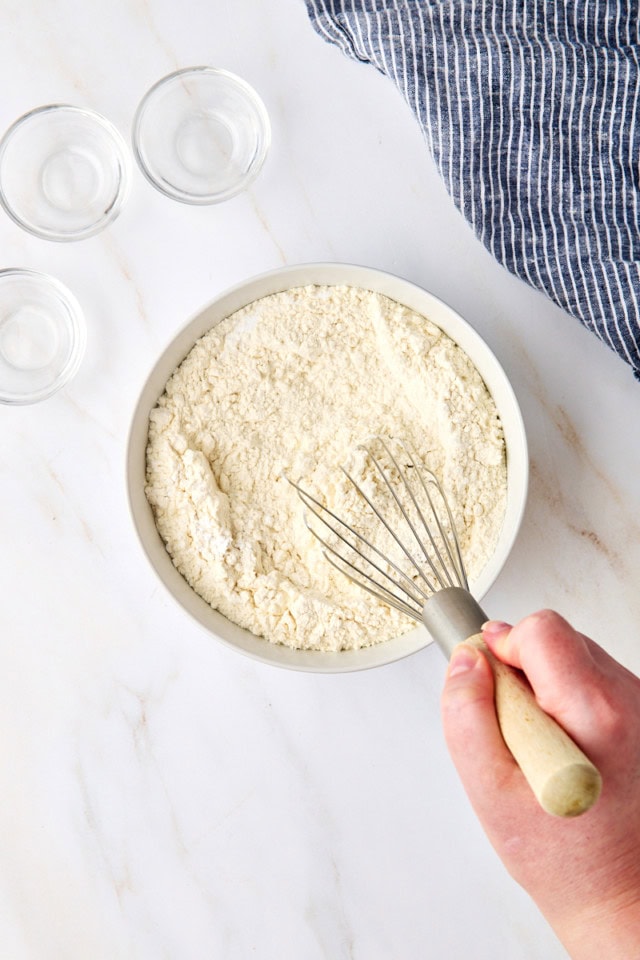 overhead view of dry ingredients being whisked together in a white bowl
