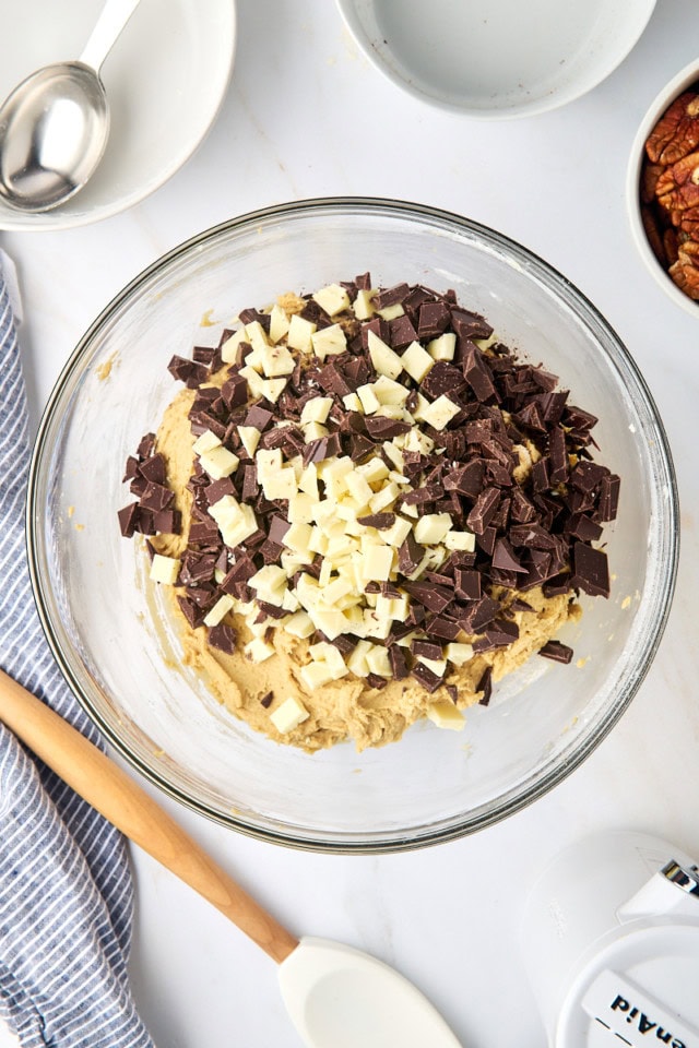 overhead view of chopped chocolate added to cookie dough