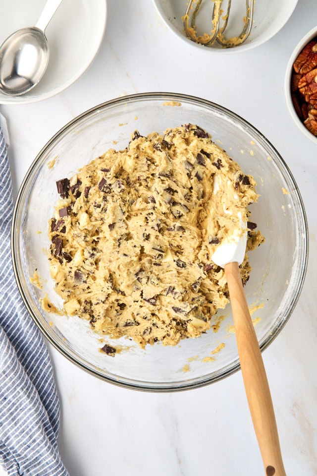 overhead view of chocolate chip cookie dough in a glass mixing bowl