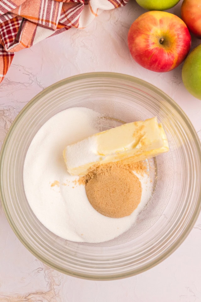overhead view of butter, sugar, and brown sugar in a glass mixing bowl