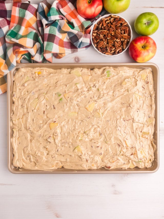 overhead view of apple cake batter spread in a half sheet pan