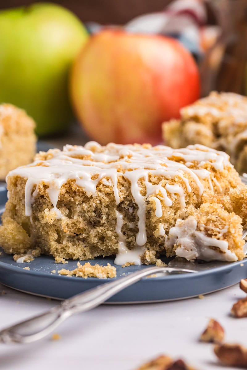a slice of apple crumb sheet cake on a plate with a bite on a fork