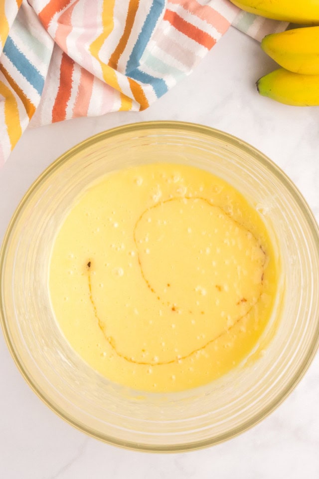 overhead view of vanilla added to partially mixed cake batter