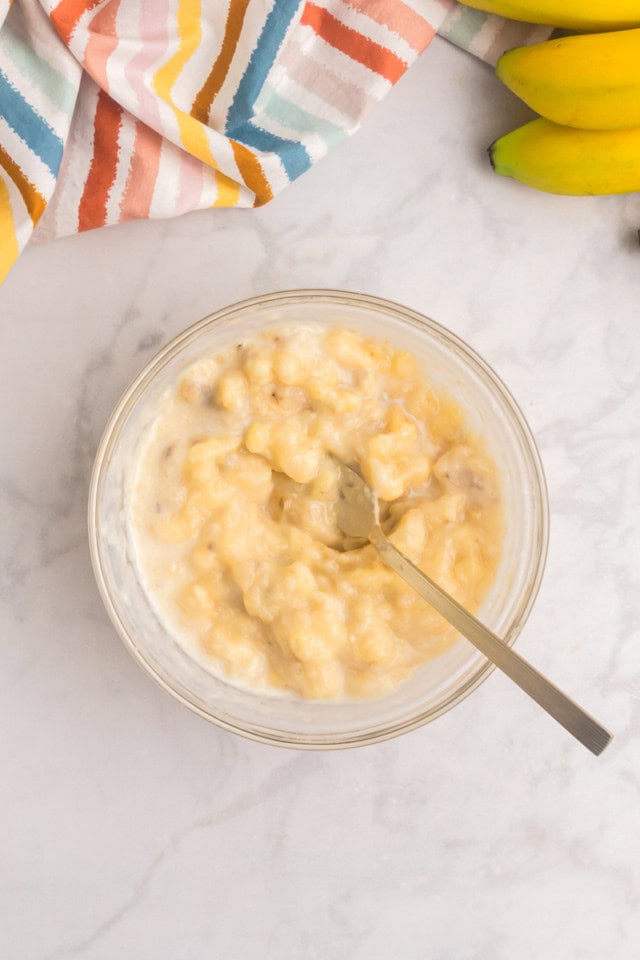 overhead view of mashed bananas and milk in a small bowl