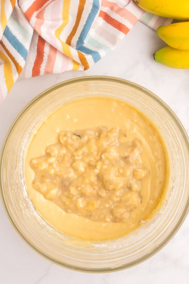 overhead view of banana and milk mixture added to cake batter