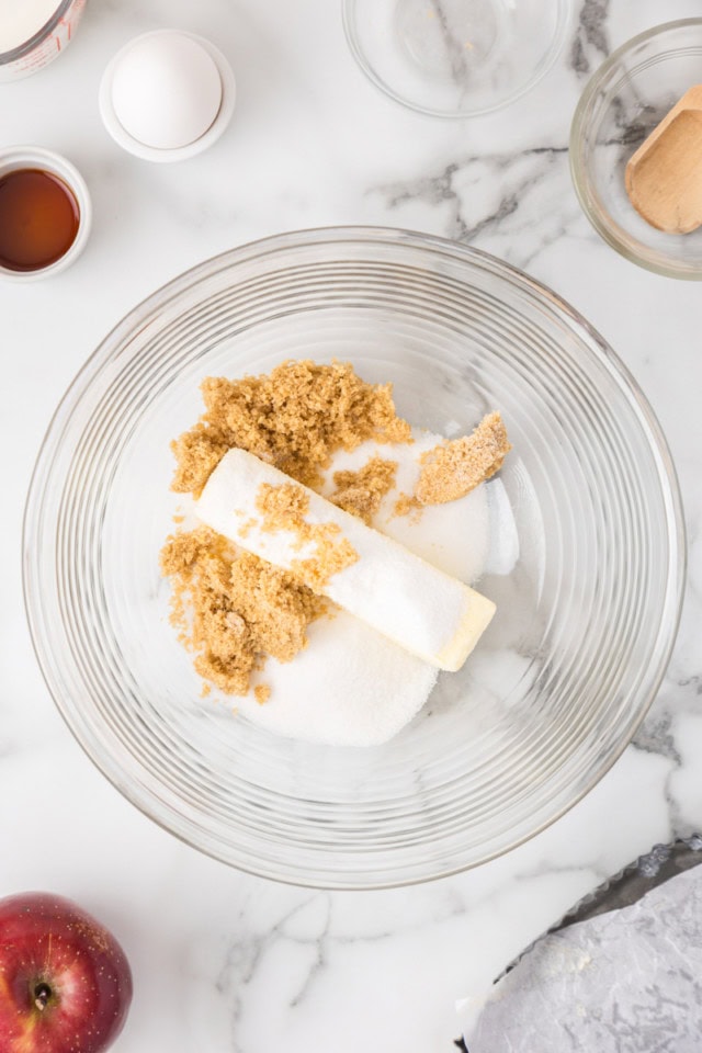 overhead view of butter, sugar, and brown sugar in a glass mixing bowl
