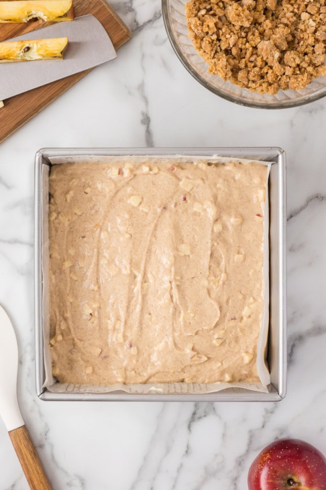 overhead view of crumb cake batter spread in a square baking pan