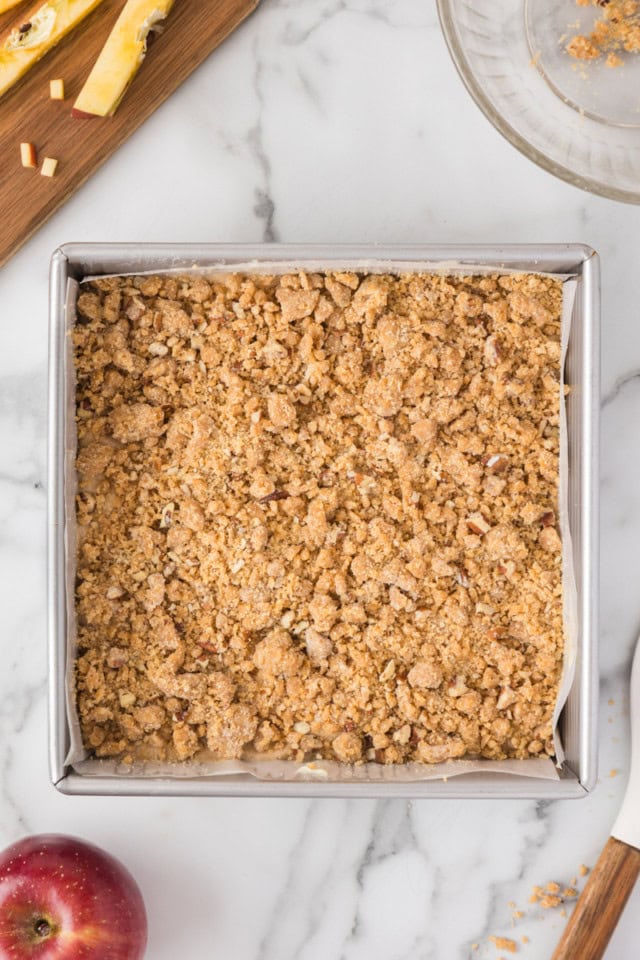 overhead view of caramel apple crumb cake in a square baking pan ready to go into the oven