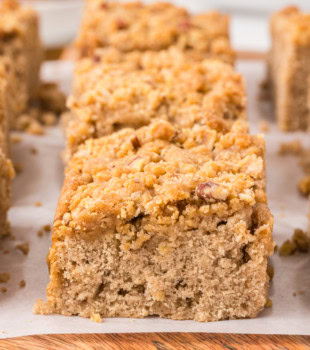 close-up of a slice of caramel apple crumb cake showing apple pieces and caramel crumb topping