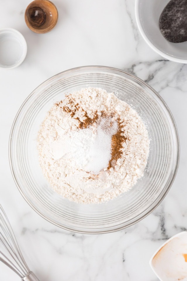 overhead view of flour, cinnamon, baking powder, and salt in a mixing bowl