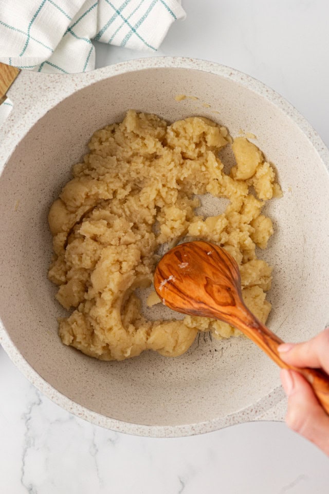 overhead view of choux pastry being stirred in a saucepan
