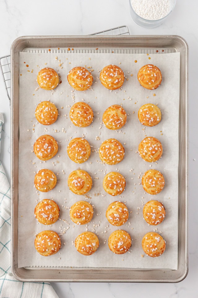 overhead view of freshly baked chouquettes on a parchment-lined baking sheet