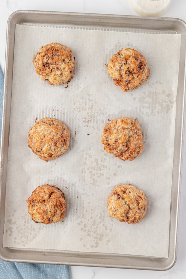 overhead view of freshly baked cinnamon bun scones on a parchment-lined baking sheet