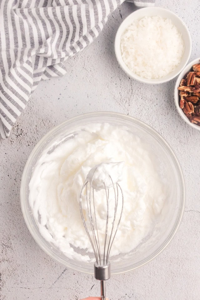 overhead view of whipped egg whites in a glass bowl
