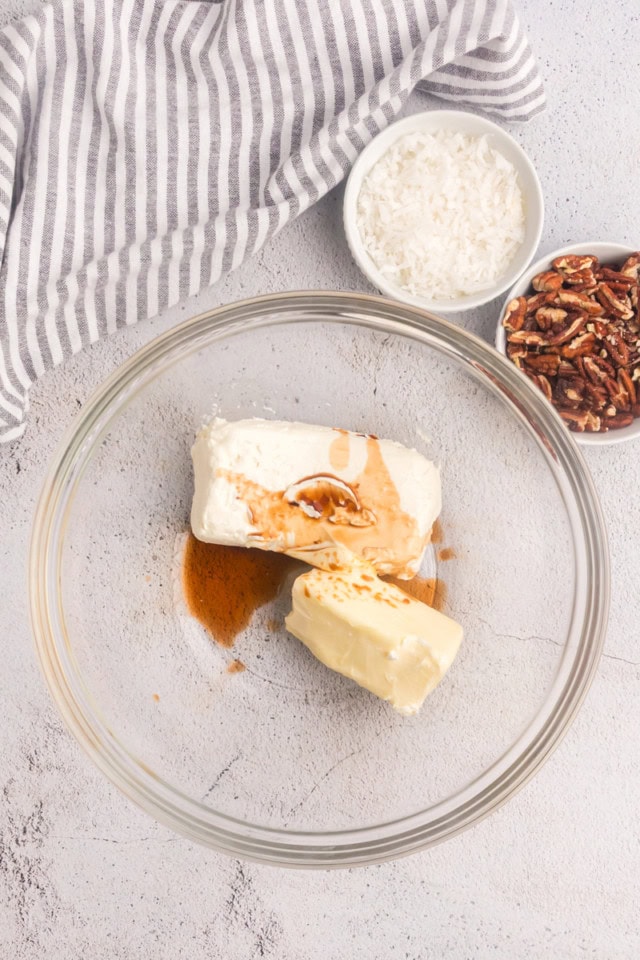 overhead view of cream cheese, butter, and vanilla in a glass mixing bowl