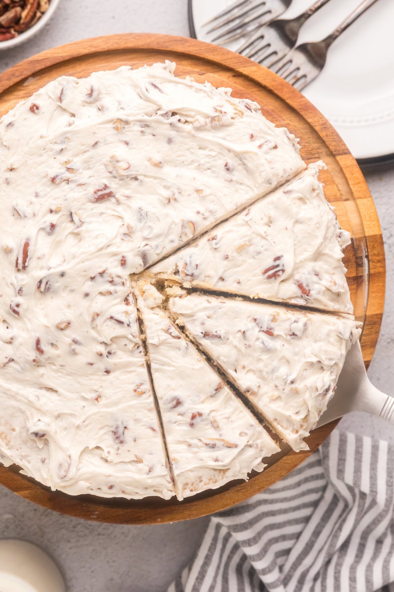 overhead view of partially sliced Italian cream cake on a wooden cake stand