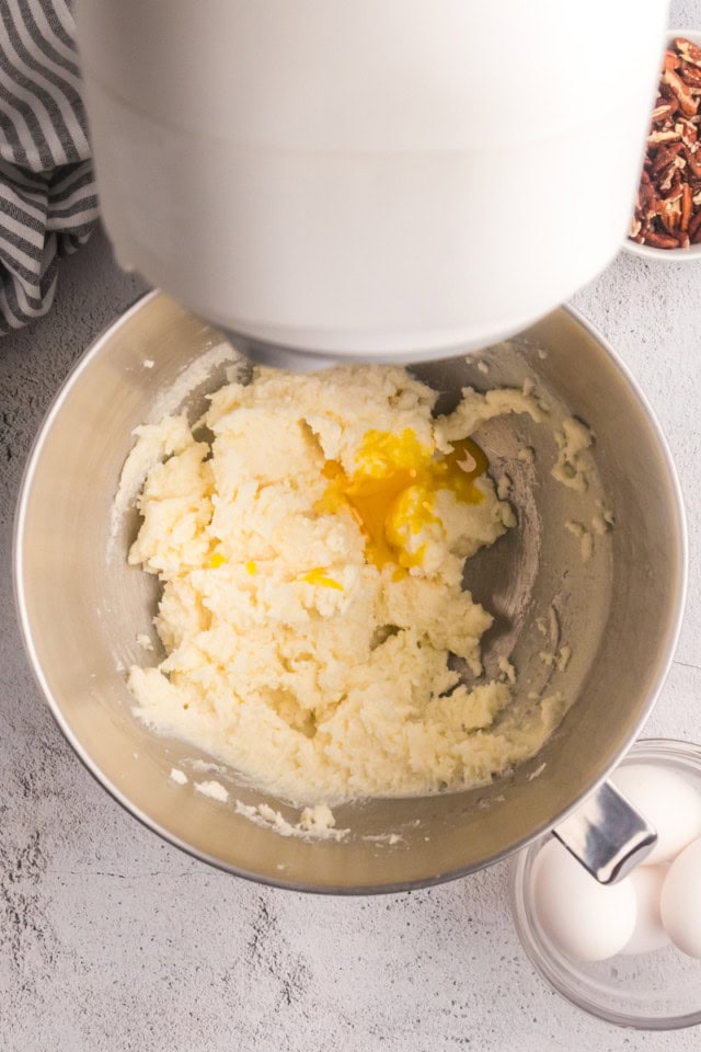 overhead view of egg added to creamed butter and sugar