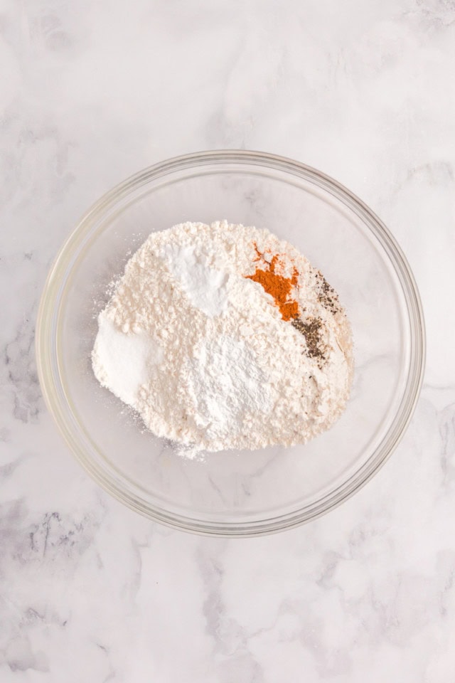 overhead view of dry ingredients for jalapeño cheddar biscuits in a glass mixing bowl