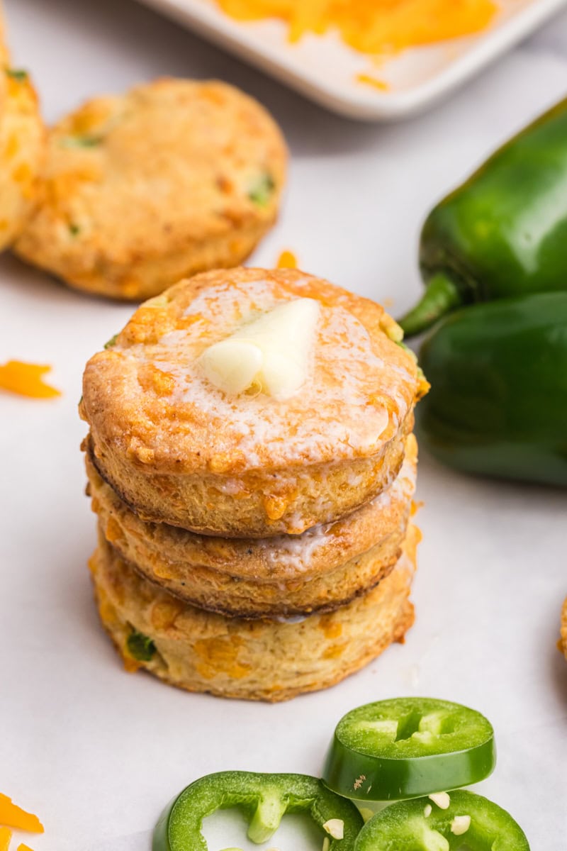 stack of three jalapeño cheddar biscuits with a pat of butter melting on top