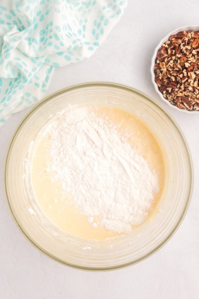 overhead view of dry ingredients added to wet ingredients for pecan pie coffee cake
