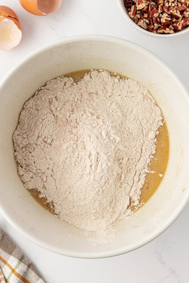 overhead view of dry ingredients added to wet ingredients for pecan praline muffins