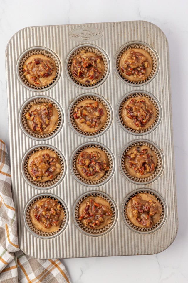 overhead view of pecan praline muffins in a muffin pan ready to go into the oven
