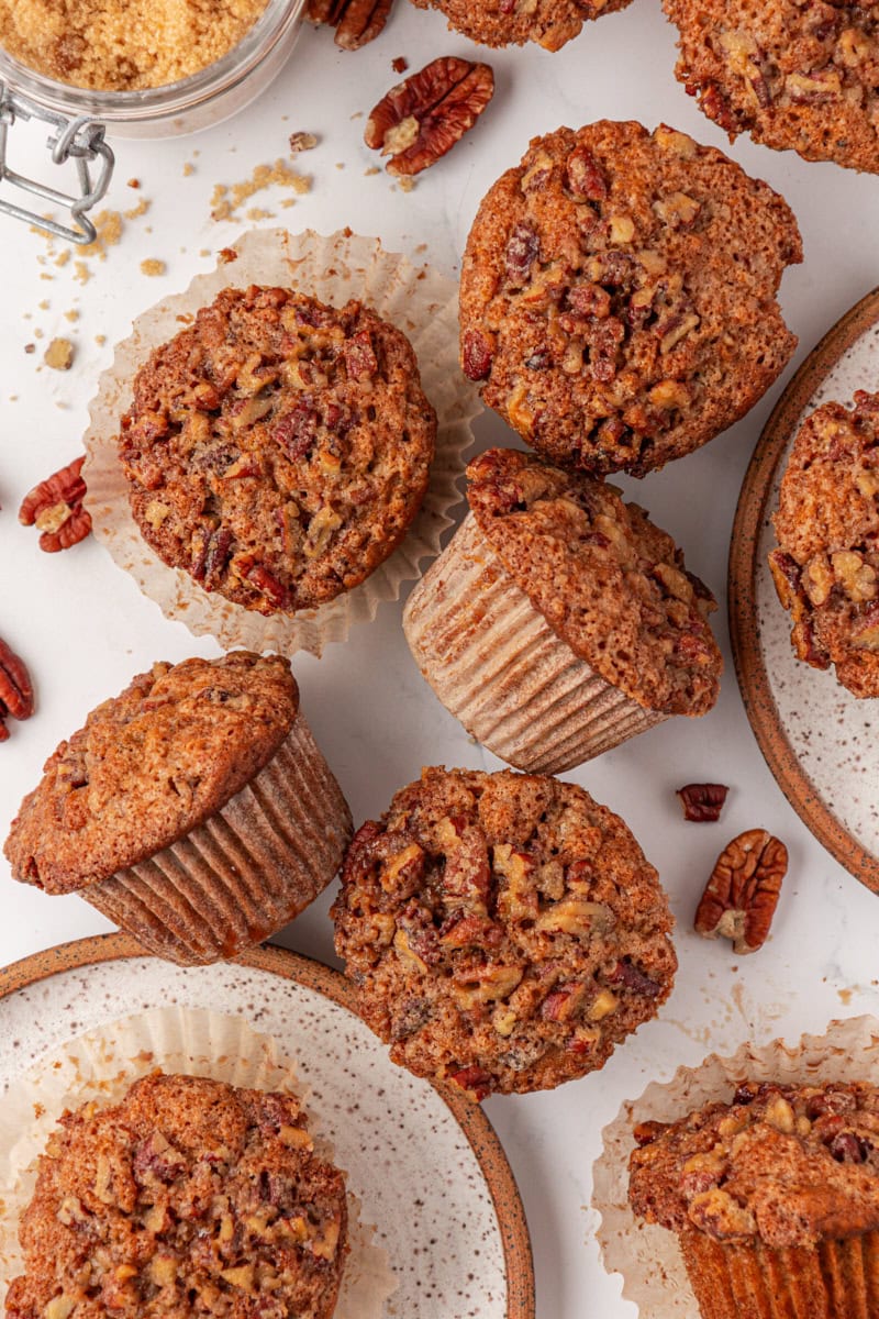 overhead view of several pecan praline muffins scattered on a white surface