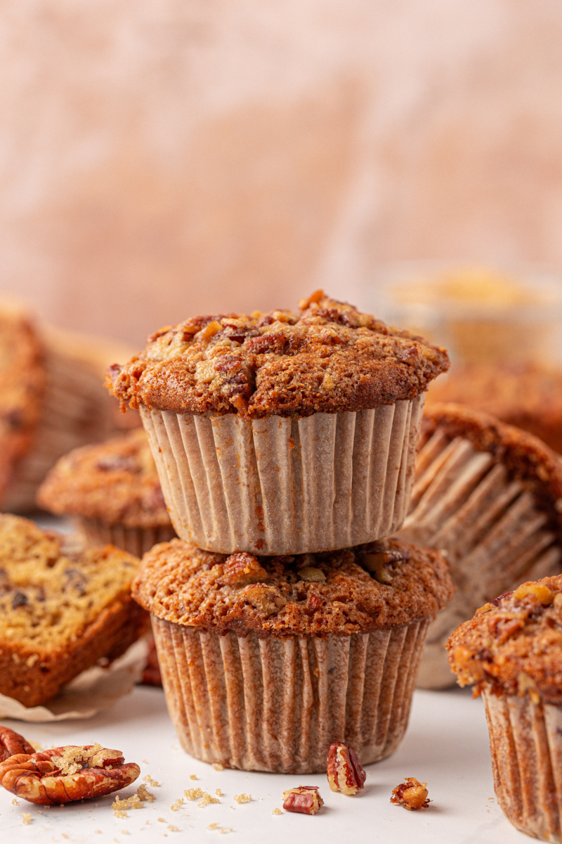 two stacked pecan praline muffins with more muffins in the background