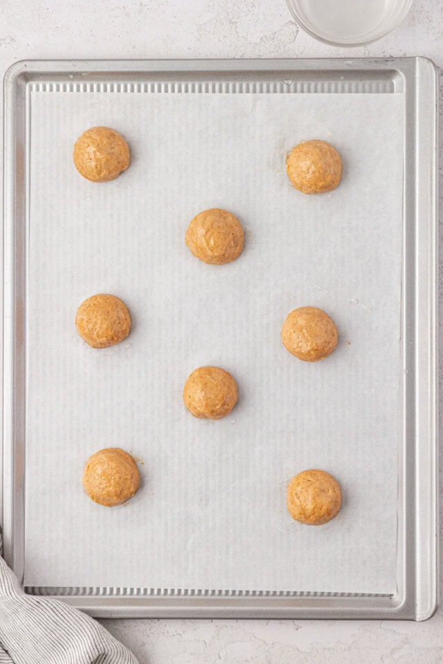 overhead view of portioned graham cake batter on a parchment-lined baking sheet