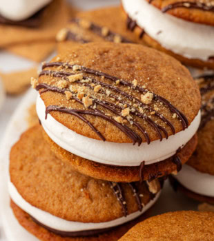 s'mores whoopie pies in a stacked pile on a white plate