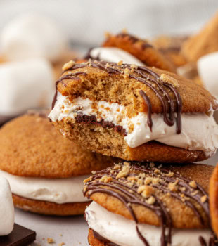 a stacked pile of s'mores whoopie pies with a bite missing from the top whoopie pie